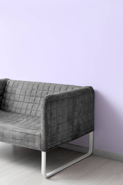 Стильный серый диван возле лиловой стены - Фото, изображение