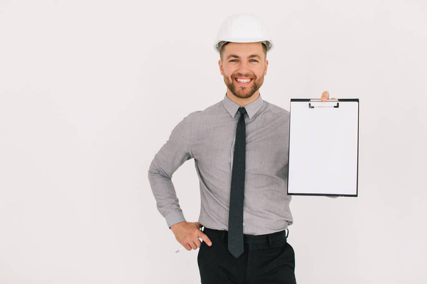 Happy male chief architect holding a folder with copy space and showing something on a white background - Photo, image