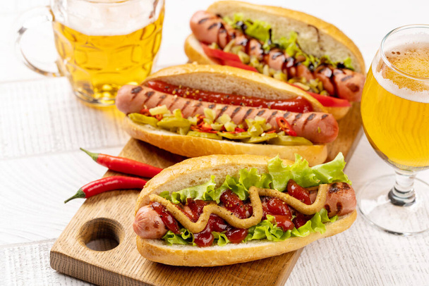 Various hot dog and beer. Homemade hotdogs on cutting board - Photo, Image