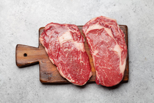 Two raw ribeye beef steaks. Top view flat lay - Фото, зображення