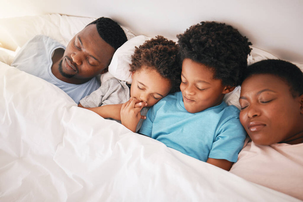Spanie, czarna rodzina i dzieci z rodzicami w łóżku, zmęczeni rankiem. Więzi, rodzicielska miłość i wsparcie z dziećmi, tata i matka odpoczynku w domu w sypialni razem. - Zdjęcie, obraz