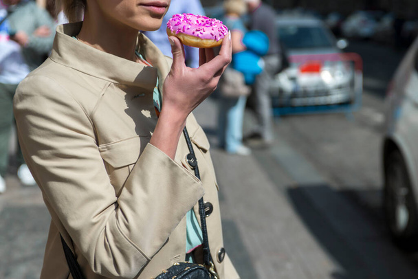 Day time shot of young woman with donuts in her hands on street - Φωτογραφία, εικόνα
