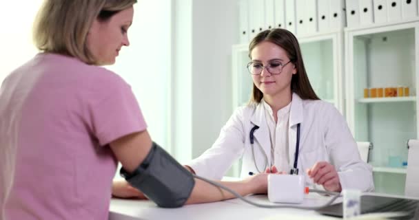 Doktor Krankenschwester Student mit einem Tonometer überprüft den Blutdruck des Patienten in der medizinischen Klinik. Bluthochdruck während der Schwangerschaft Ursachen und Symptome - Filmmaterial, Video