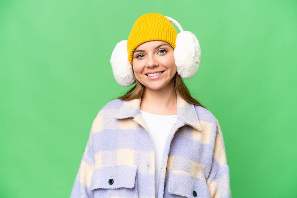 Young blonde woman wearing winter muffs over isolated chroma key background laughing - Foto, afbeelding