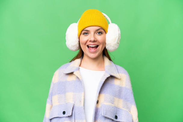 jonge blonde vrouw dragen winter moffen over geïsoleerde chroma key achtergrond met verrassing gezichtsuitdrukking - Foto, afbeelding