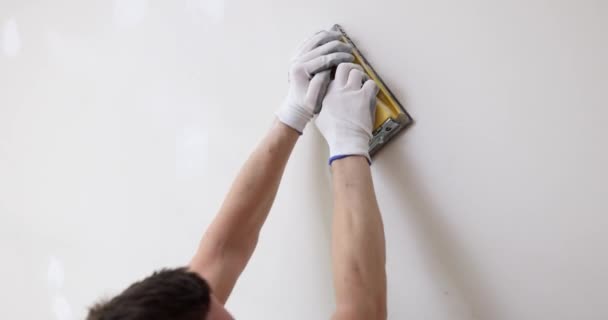 Hand sanding wall with sandpaper on white wall. Abrasive toolsand do it yourself - Footage, Video
