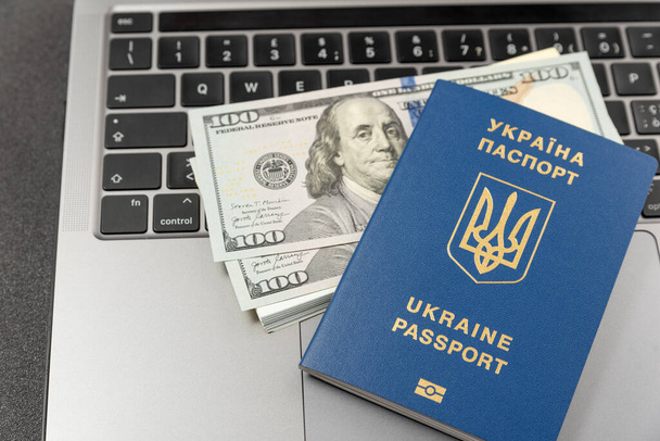 Ukrainian passport, cash dollars and a laptop. Online work for Ukrainians. Registration of documents online in Ukraine. Cash payments to Ukrainians - Foto, imagen