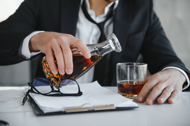 Young businessman drinking from stress. - Фото, зображення