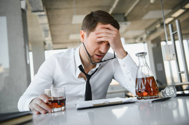 Alcoholismo en el trabajo. Empleado cansado beber alcohol en el lugar de trabajo, no puede manejar el estrés - Foto, imagen