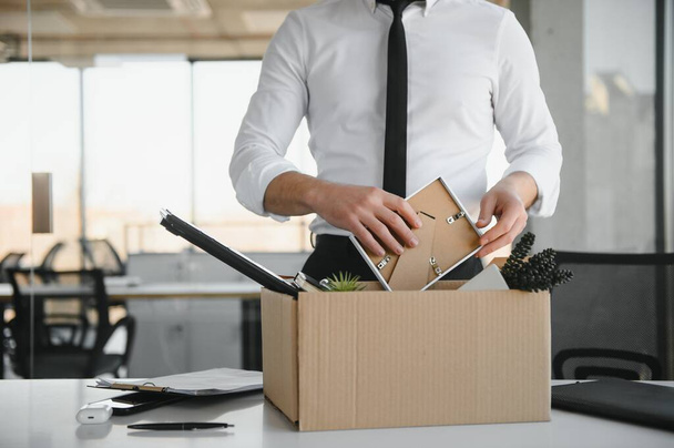 Close-up Of A Businessperson Carrying Cardboard Box During Office Meeting. - Foto, imagen
