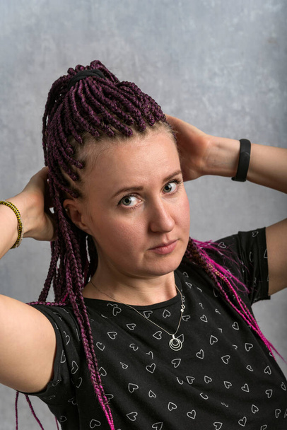 Middle-aged woman with pink dreadlocks wears T-shirt with heart pattern. Hipster style. Vertical frame - Фото, зображення