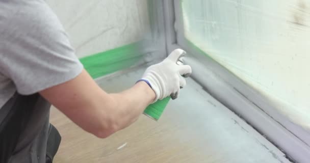 Ο κατασκευαστής ζωγραφίζει ένα στρώμα παραθύρου με λευκό σπρέι. Χαρακτηριστικά της βαφής πόρτα και τις πλαγιές παράθυρο - Πλάνα, βίντεο
