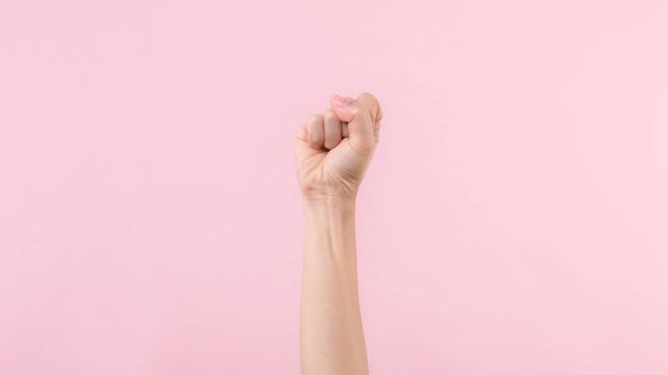 Woman fist fight for human rights and feminist with pink pastel background. Women empowerment, strength, equality and courage concept - Photo, Image