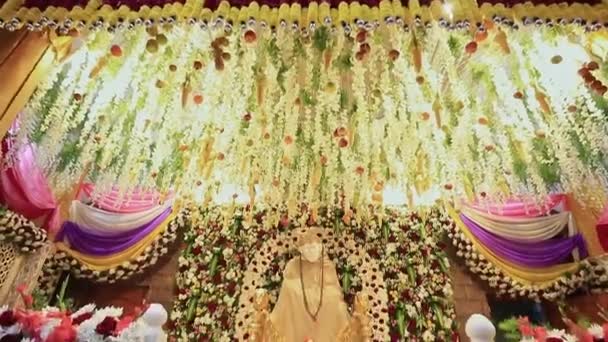 Una veduta inclinata dell'idolo Sai Ram o Sai Baba tra decorazioni floreali durante l'evento religioso - Filmati, video