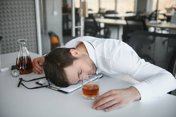 Young businessman drinking from stress. - Foto, Imagem