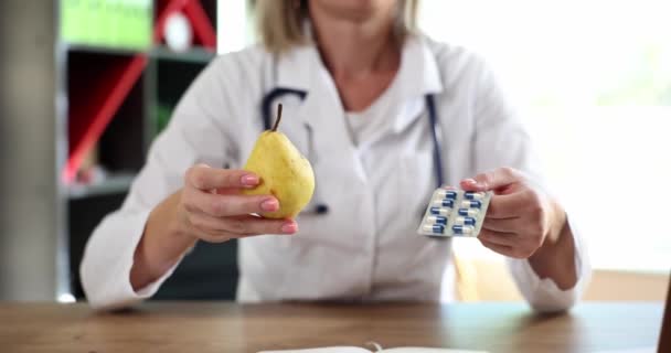 Médecin offre le choix de fruits de poire ou de pilules médicales. Principes de base d'une bonne nutrition - Séquence, vidéo