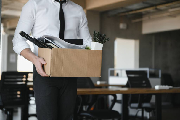 Close-up Of A Businessperson Carrying Cardboard Box During Office Meeting. - Foto, Imagen