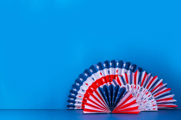 Happy Labor Day, Presidents Day, Fourth of July Independent Day, Memorial day, Columbus day background. Blue background with USA flag color paper fans and decorations, party accessories - Fotografie, Obrázek