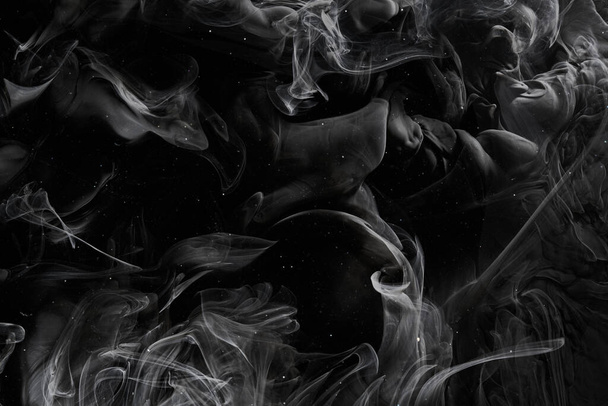 Fond noir abstrait de l'océan. Éclaboussures et vagues de peinture sous l'eau, nuages de fumée interstellaire en mouvement - Photo, image