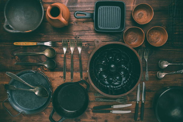 Кухонная утварь, кухонные принадлежности, на деревянном фоне. Коллекция старинной посуды. - Фото, изображение