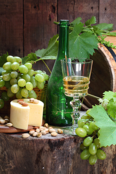 Still-life with wine, salty cheese, nuts and grapes - Photo, Image