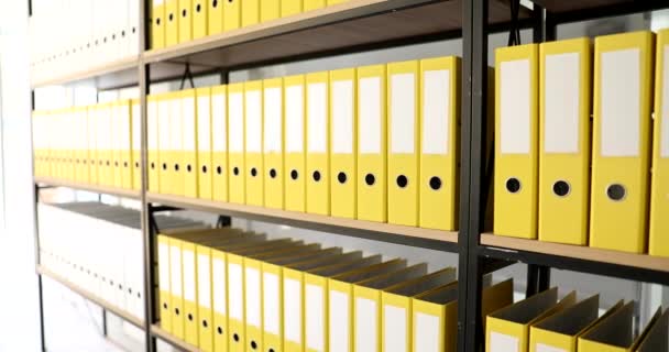 Großaufnahme von leuchtend gelben Ordnern im Büroregal. Archivierung und Aufbewahrung von Dokumenten - Filmmaterial, Video