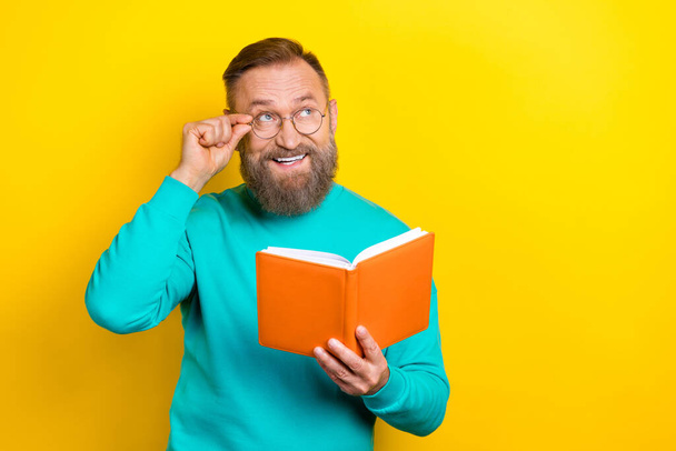Photo portrait of attractive grandpa touch specs notepad look empty space wear trendy aquamarine outfit isolated on yellow color background. - 写真・画像