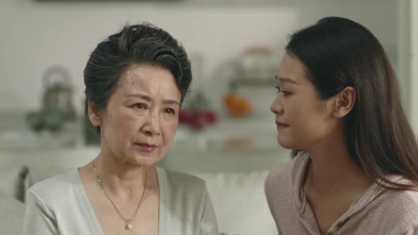 loving and caring asian adult daughter consoling sad senior mother at home - Filmagem, Vídeo
