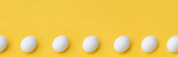 Banner hecho de huevos de pollo blanco en fila sobre fondo amarillo, vista superior. Copiar espacio - Foto, Imagen
