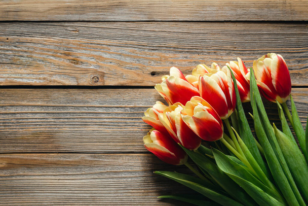 Stylish greeting card. Fresh tulips on wooden background, flat lay. Floral Greeting card template with space for text. Happy womens day. Happy Mothers day, copy space. - Photo, Image