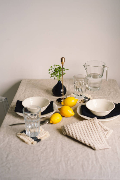 Vintage τραπέζι με λινά χαρτοπετσέτες και κίτρινα λεμόνια. Τραπέζι διακόσμησης. Κλείσε. Ζεστό ήρεμο γεύμα το πρωί στη λιακάδα. - Φωτογραφία, εικόνα