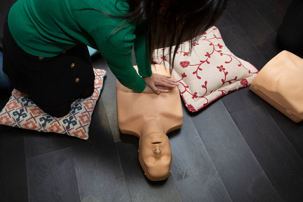 Two people practice first aid and cpr resuscitation with a cpr resuscitation manikin - Photo, Image