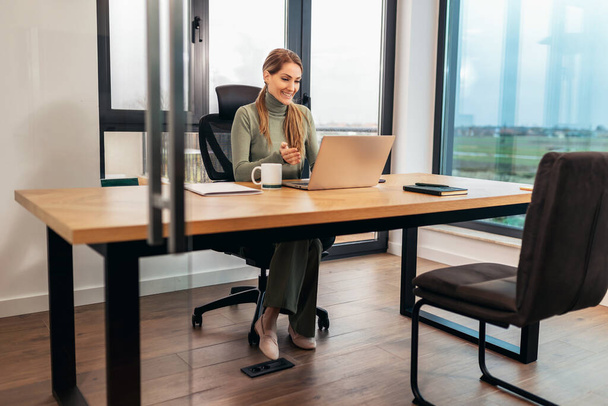 Ritratto di una donna di successo, donna d'affari che lavora in un ufficio moderno su laptop. - Foto, immagini