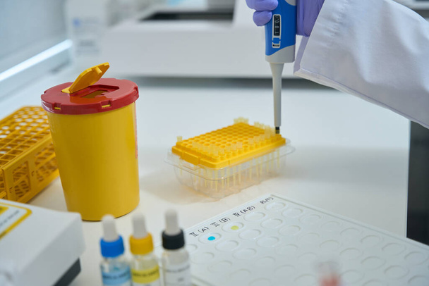 Asystent laboratoryjny w laboratorium chemicznym przeprowadza badania na grupę krwi, używa specjalnych odczynników - Zdjęcie, obraz