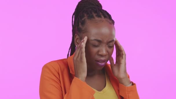 Fejfájás, stressz és szorongás egy fekete nővel a stúdióban, rózsaszín háttérrel, kiégve. Mentális egészség, fájdalom és migrén egy fiatal nő dörzsöli a halántékát kellemetlen érzéssel. - Felvétel, videó