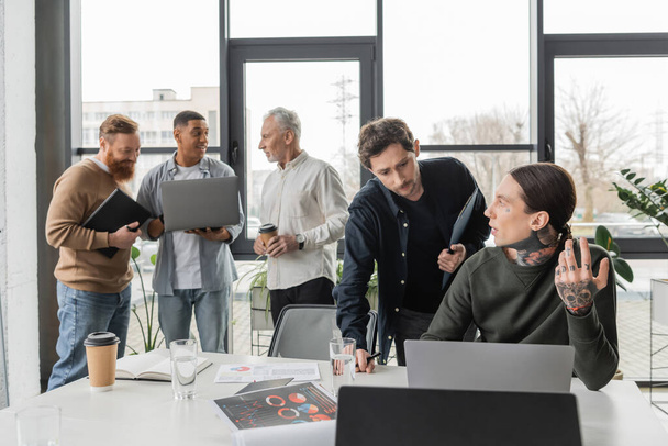 Empresários com prancheta e laptop conversando durante reunião no escritório - Foto, Imagem