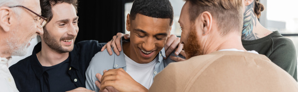 Cheerful group hugging african american man during anonymous alcoholics meeting in rehab center, banner - Fotografie, Obrázek