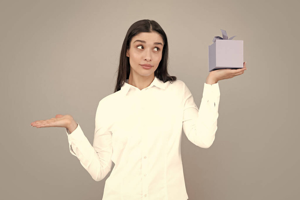 Happy birthday. Woman holding gift box with ribbon. Studio portrait over gray background - Fotoğraf, Görsel
