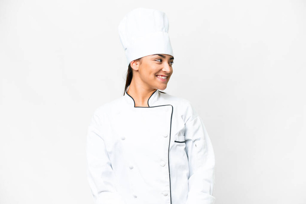 Mujer joven Chef sobre fondo blanco aislado mirando lado - Foto, Imagen