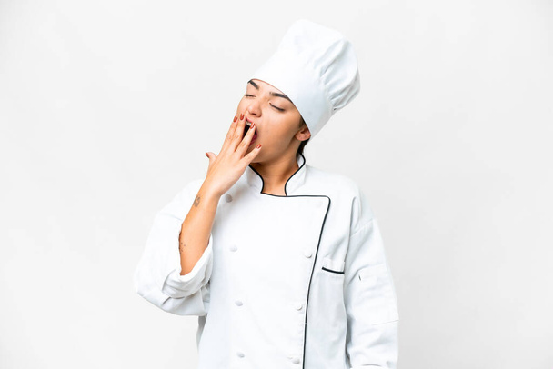 Mujer joven Chef sobre fondo blanco aislado bostezando y cubriendo la boca abierta con la mano - Foto, Imagen