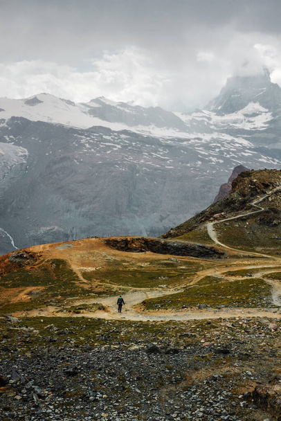 Ścieżka wśród gór śniegu. Zermatt, Alpy Szwajcarskie. Przygoda, wędrówki po Szwajcarii, Europie. Miejsce na samotność, ciszę i relaks. Zielona trawa i kamienie. - Zdjęcie, obraz