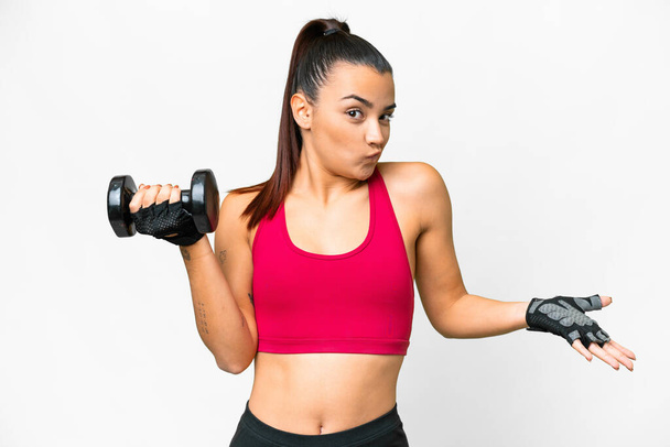Young sport woman making weightlifting making doubts gesture while lifting the shoulders - Photo, Image