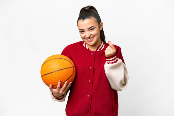 Young Woman playing basketball over isolated white background making money gesture - Foto, Bild