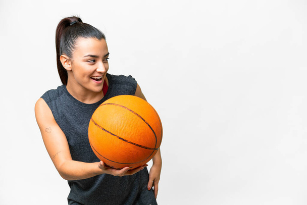 Young beauty woman over isolated white background playing basketball - Foto, immagini