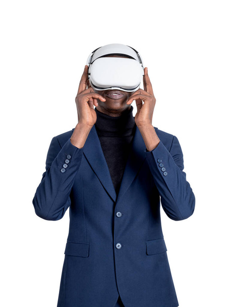 African businessman wearing vr glasses headset, isolated over white background, blue suit. Concept of metaverse and digital world - Fotoğraf, Görsel