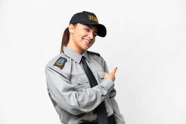 Молодая охраняемая женщина на изолированном белом фоне указывает назад - Фото, изображение