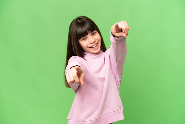Маленька дівчинка над ізольованим зеленим хромовим ключем, що вказує спереду з щасливим виразом
 - Фото, зображення