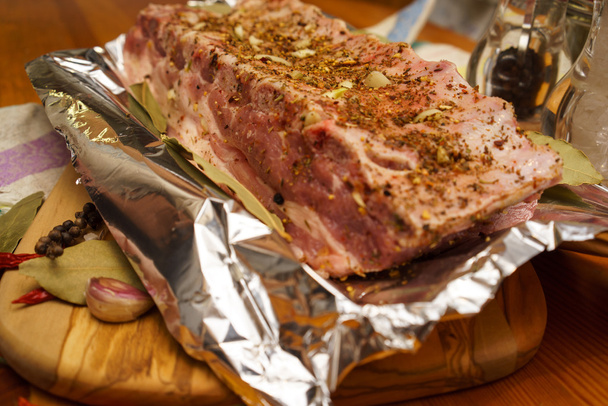 Costillas de cerdo frescas, carne marinado y preparado para asar con ajo en una lámina
 - Foto, Imagen