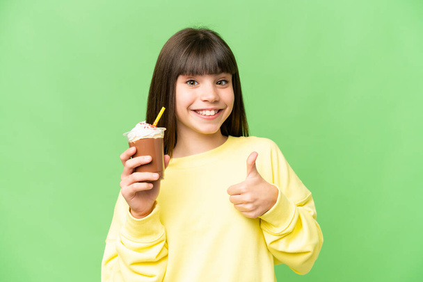Little girl with chocolat cream over isolated chroma key background with thumbs up because something good has happened - Foto, imagen