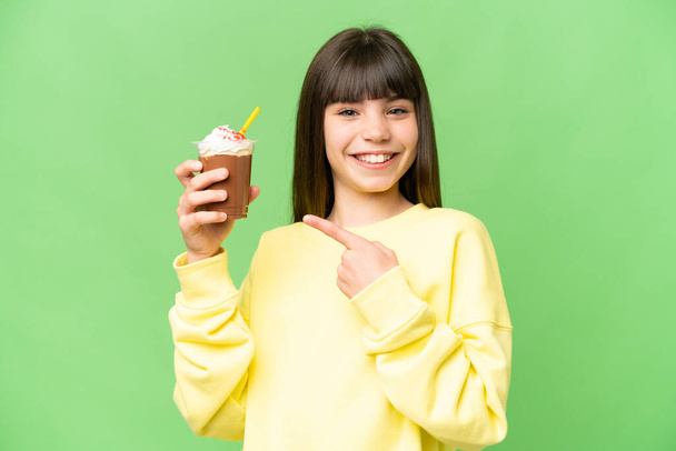 Little girl with chocolat cream over isolated chroma key background and pointing it - Valokuva, kuva